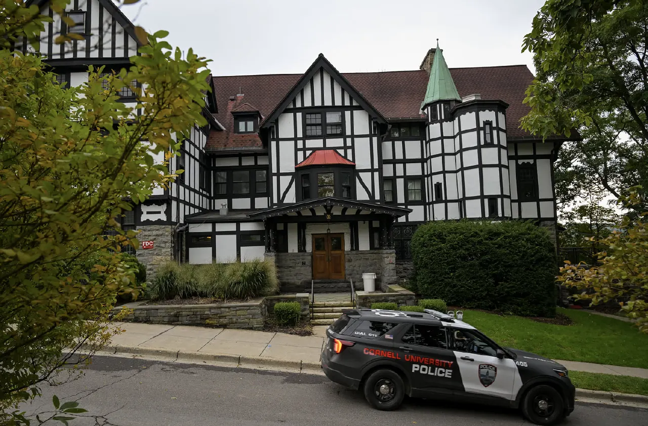 Tudor-style fraternity house with a Cornell University Police vehicle parked outside.